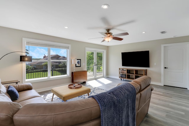 living room with ceiling fan, french doors, and light hardwood / wood-style floors