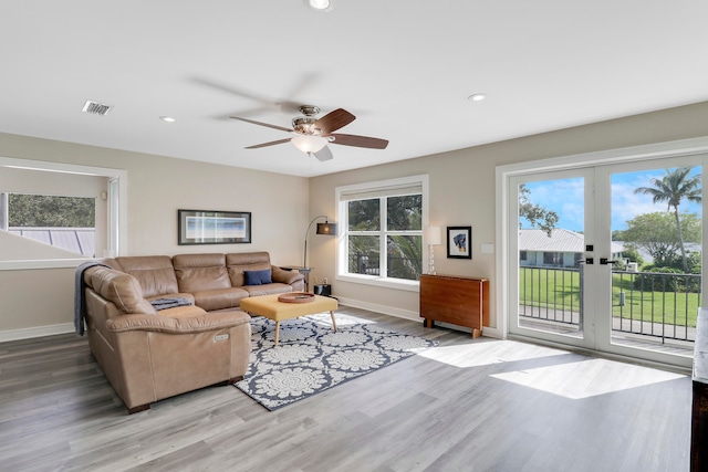 living room with ceiling fan, french doors, and light hardwood / wood-style flooring