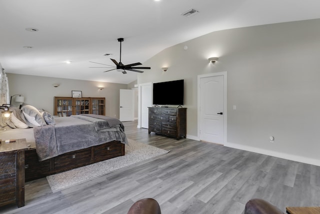 unfurnished bedroom with ceiling fan, lofted ceiling, and light hardwood / wood-style flooring