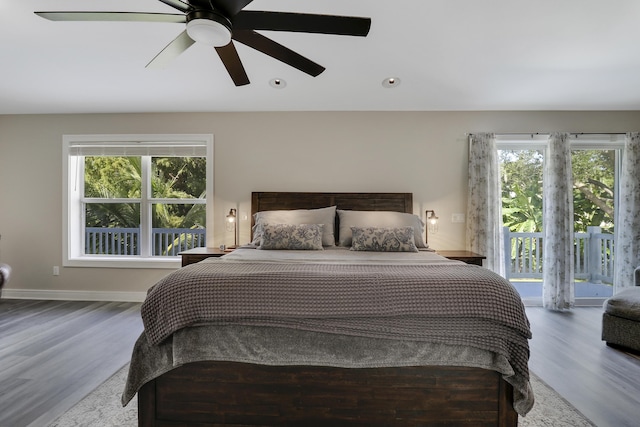 bedroom with multiple windows, access to exterior, wood-type flooring, and ceiling fan