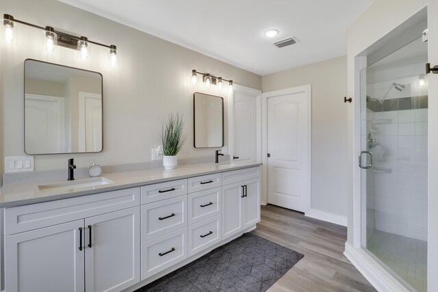 bathroom featuring an enclosed shower, vanity, and hardwood / wood-style flooring