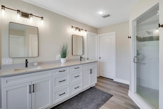 bathroom with vanity, wood-type flooring, and walk in shower