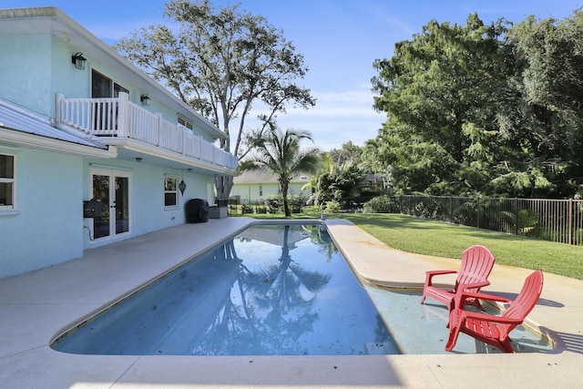 view of pool featuring a lawn, a patio, and french doors