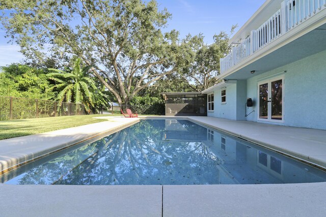 view of pool featuring a lawn