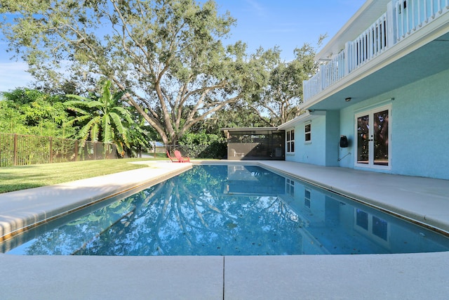 view of swimming pool featuring a yard, a patio area, and french doors