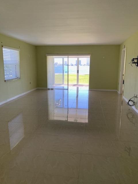 2936 Lake Shore Dr Unit 101, Riviera Beach, FL 33404 - tiled empty room featuring plenty of natural light and baseboards