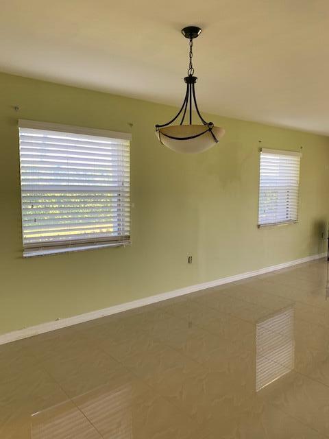 empty room featuring plenty of natural light and tile patterned floors