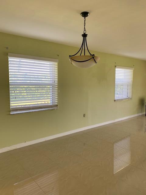 2936 Lake Shore Dr Unit 101, Riviera Beach, FL 33404 - tiled empty room featuring baseboards