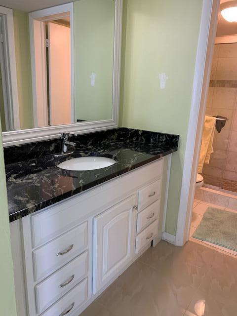 2936 Lake Shore Dr Unit 101, Riviera Beach, FL 33404 - bathroom with a stall shower, toilet, and vanity