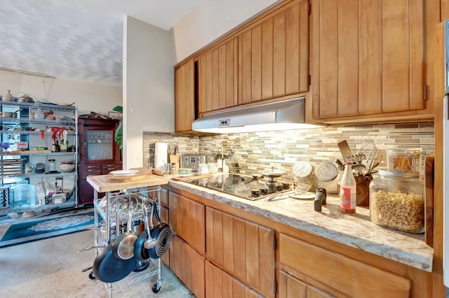 kitchen featuring light stone counters, black electric cooktop, and tasteful backsplash