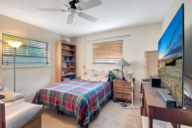 carpeted bedroom featuring ceiling fan and multiple windows