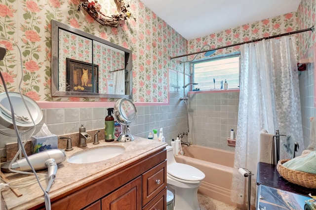 full bathroom with tile walls, shower / tub combo with curtain, vanity, and toilet