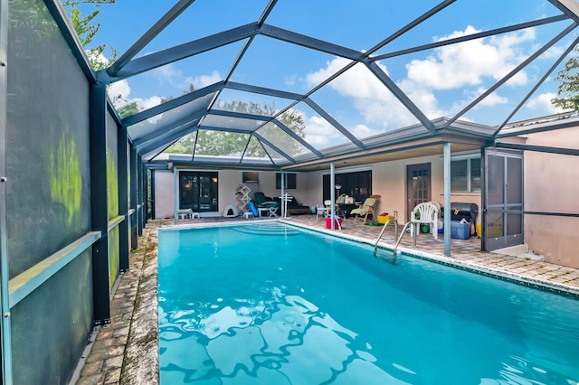 view of swimming pool featuring a lanai and a patio area