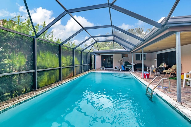 view of swimming pool with a patio, glass enclosure, and ceiling fan