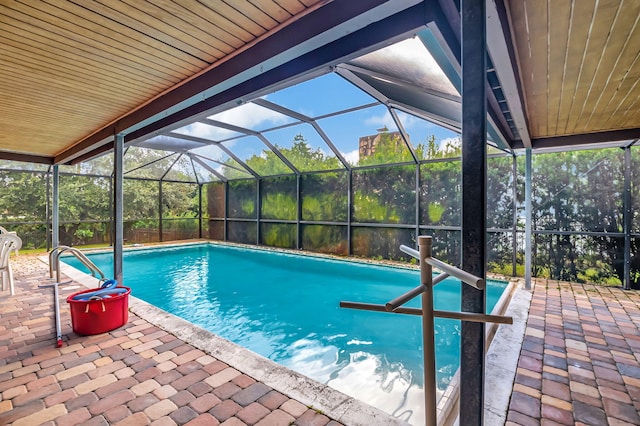 view of swimming pool with a patio and a lanai