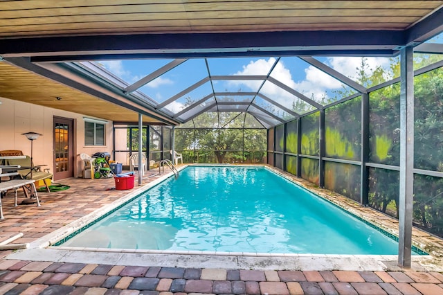 view of swimming pool with glass enclosure and a patio area