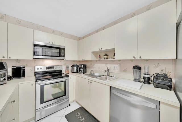 kitchen with sink, light tile patterned floors, and stainless steel appliances