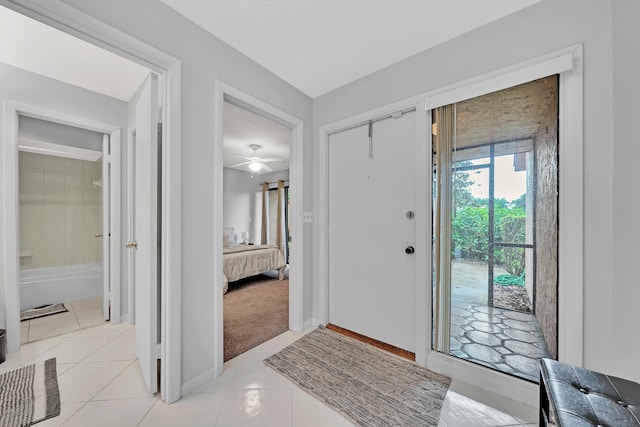 tiled entrance foyer featuring ceiling fan and a textured ceiling