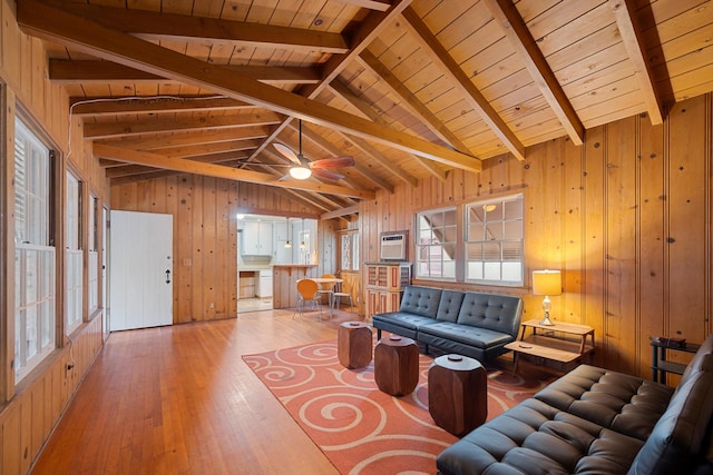 living room with ceiling fan, light hardwood / wood-style flooring, lofted ceiling with beams, wooden walls, and wood ceiling