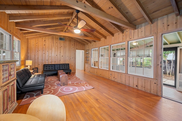 living room with wood ceiling, lofted ceiling with beams, plenty of natural light, and hardwood / wood-style floors