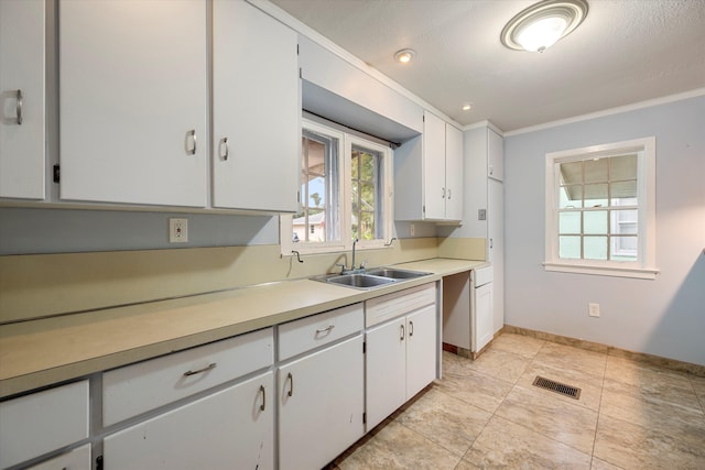 kitchen with crown molding, sink, white cabinets, and a textured ceiling