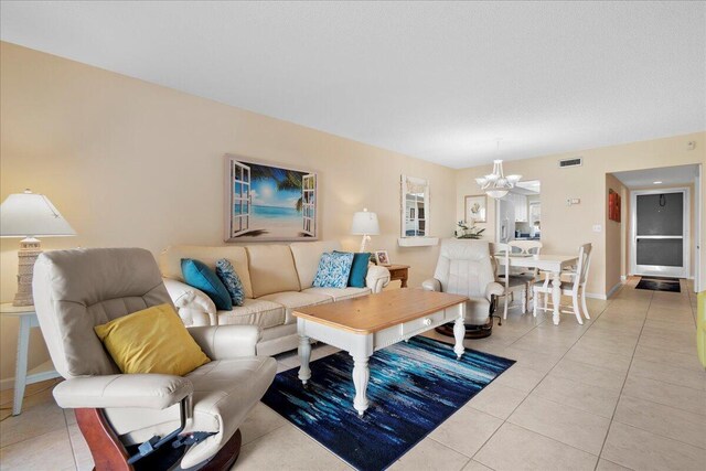 living room with light tile patterned flooring and a notable chandelier