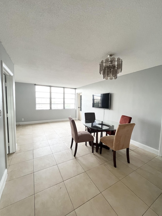 tiled dining space featuring a textured ceiling