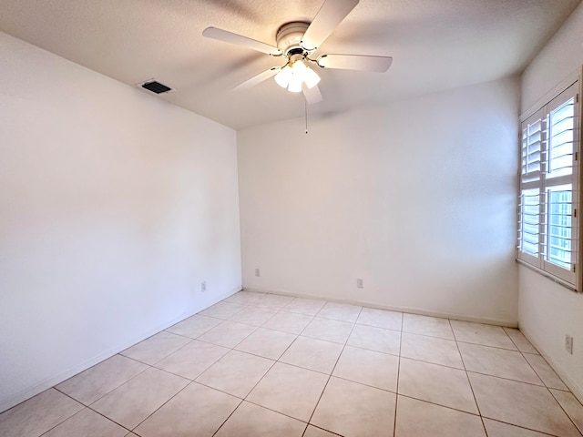 unfurnished room with ceiling fan, a textured ceiling, and light tile patterned floors