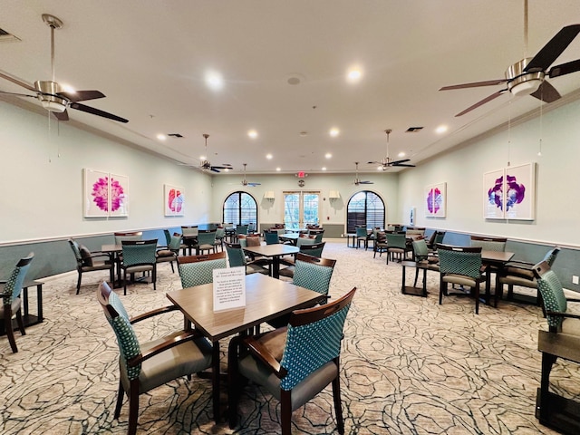 dining space with ceiling fan and light colored carpet