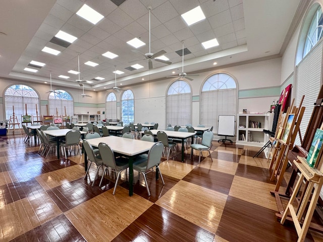 dining space with ceiling fan, a paneled ceiling, hardwood / wood-style floors, and a wealth of natural light