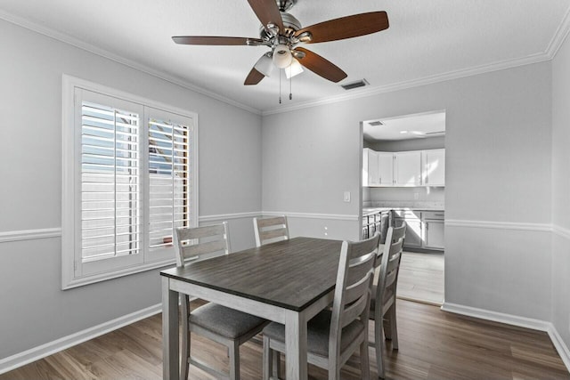 dining area featuring wood-type flooring, ceiling fan, and crown molding