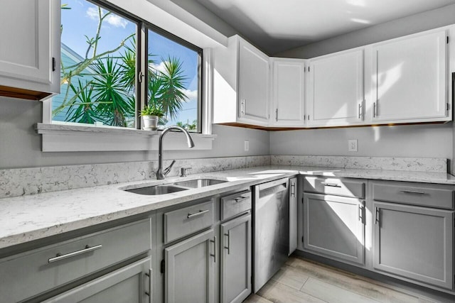 kitchen featuring stainless steel dishwasher, plenty of natural light, gray cabinets, and sink