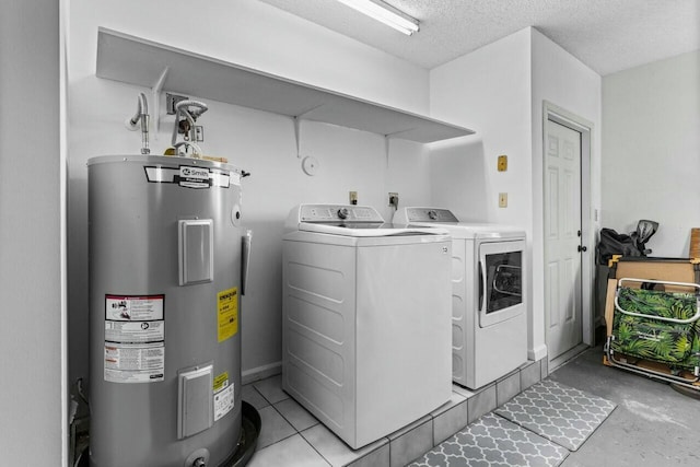 washroom with washing machine and dryer, electric water heater, and a textured ceiling