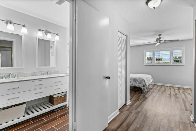 bathroom with wood-type flooring, vanity, a textured ceiling, and ceiling fan