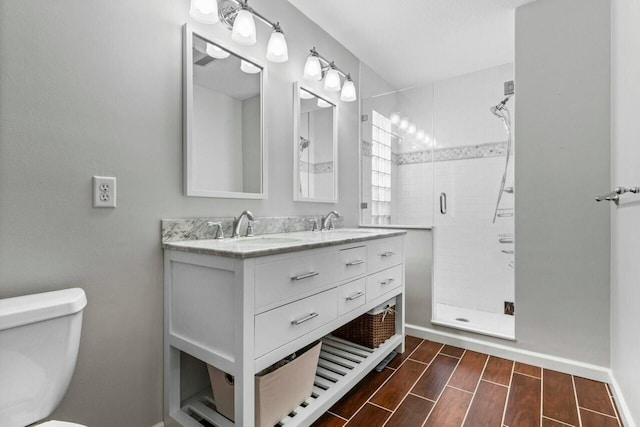 bathroom featuring vanity, toilet, and a shower with shower door