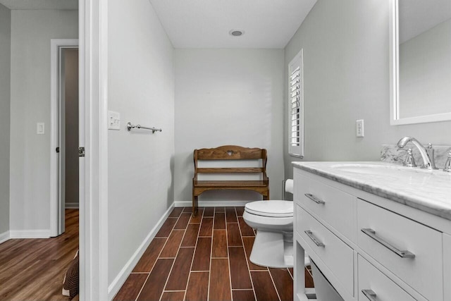 bathroom with vanity, toilet, and wood-type flooring