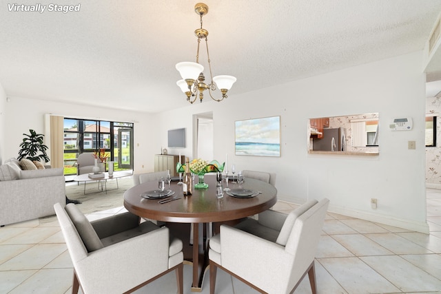 tiled dining area with an inviting chandelier and a textured ceiling