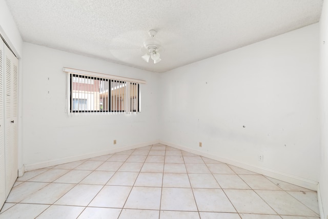 tiled empty room with a textured ceiling and ceiling fan