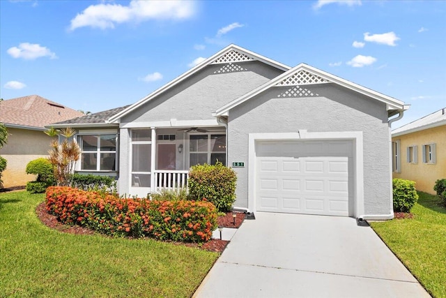 view of front of house with a garage, a front lawn, and a sunroom