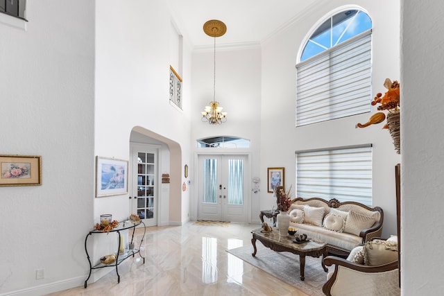 living room featuring a chandelier, a high ceiling, and crown molding