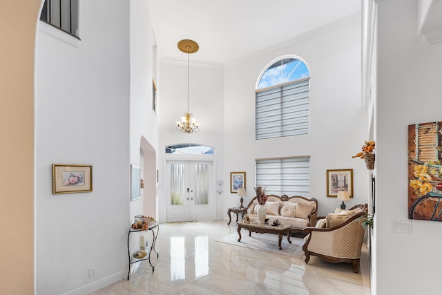 entrance foyer featuring a towering ceiling, crown molding, and an inviting chandelier