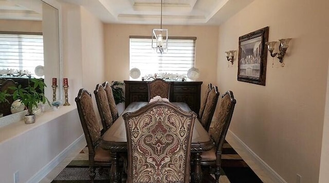 dining area featuring a raised ceiling and a wealth of natural light