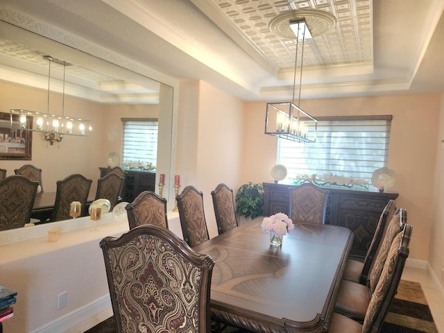 dining room with a raised ceiling, crown molding, and a healthy amount of sunlight