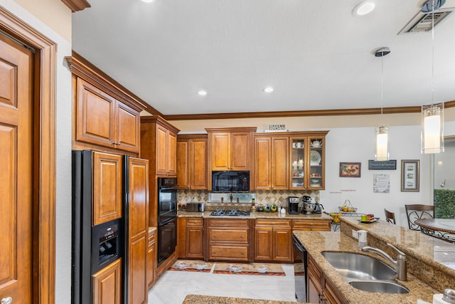 kitchen featuring black appliances, backsplash, light stone countertops, and sink