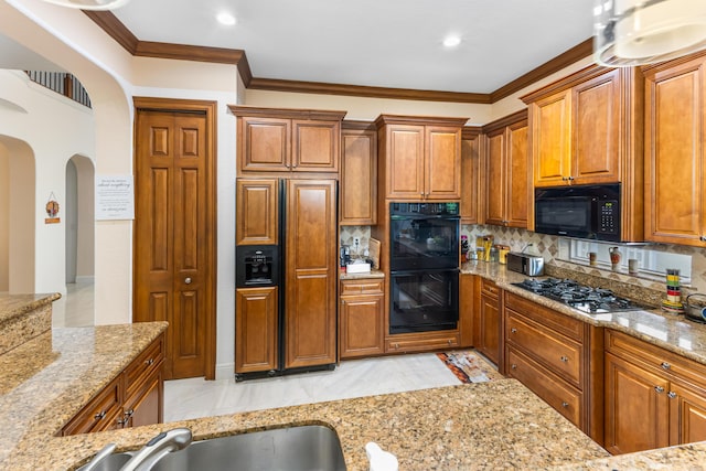 kitchen with black appliances, sink, decorative backsplash, ornamental molding, and light stone counters