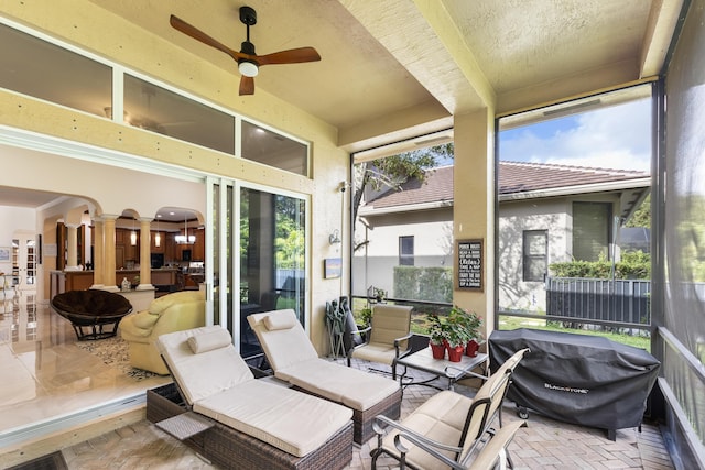 sunroom / solarium featuring ceiling fan