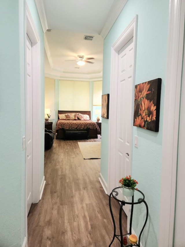 hallway featuring light wood-type flooring and ornamental molding