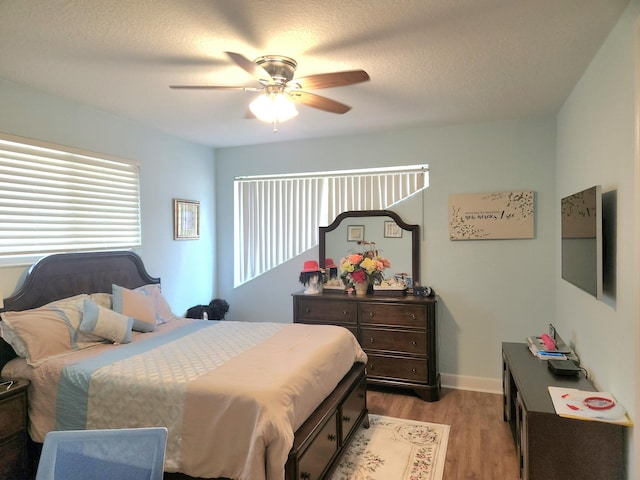 bedroom featuring a textured ceiling, light hardwood / wood-style floors, and ceiling fan