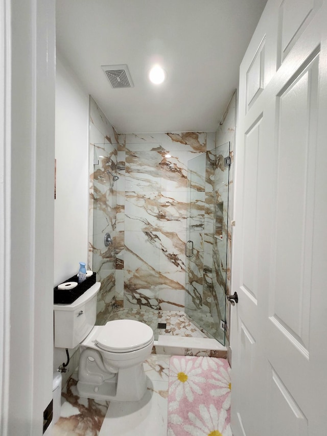 bathroom featuring toilet and a shower with shower door