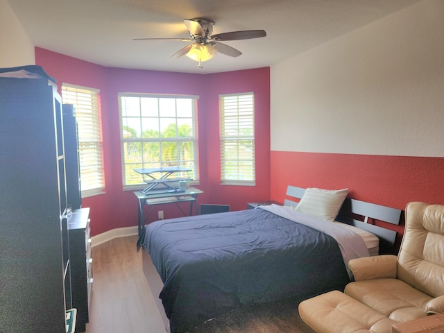 bedroom with light hardwood / wood-style floors and ceiling fan